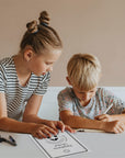 two young children working on gratitude worksheets